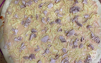 Засыпать частью сыра, выложить куриное филе.