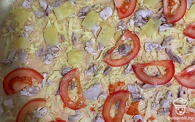 Сверху выложить помидор и дольки консервированного ананаса, остатки сыра.