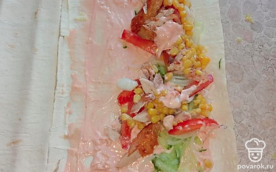 Смазать лаваш соусом и выложить начинку. Аккуратно завернуть в рулет. 