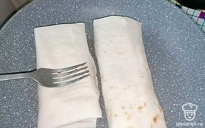 Лаваш смазываем готовым соусом и добавляем готовые ингредиенты. Заворачиваем и греем на сковороде.