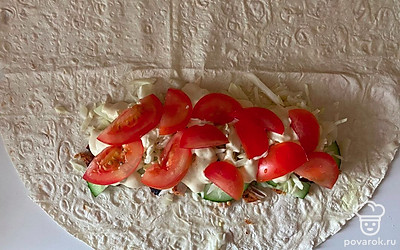 Тонкий лаваш разрезать пополам, выложить на него куриное филе, огурец, капусту, смазать соусом, сверху выложить помидор. 