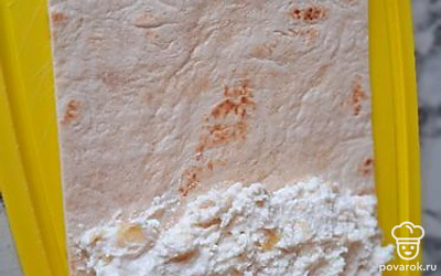 Лаваш или лепешку нарежьте полосками любых размеров, чтобы завернуть начинку. Выложите творожно-банановую смесь на полоски.