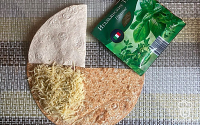 Мясо накройте пустым кусочком лаваша. На третий отсек натрите сыр и посыпьте сверху пряной травой.