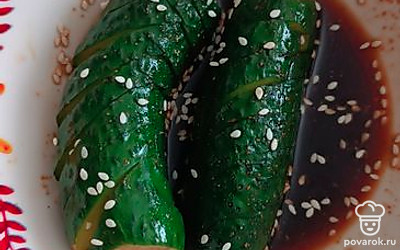 Достаньте огурцы из холодильника и посыпьте кунжутом.