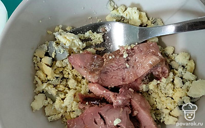 С печени трески слейте  масло и добавьте  к желткам. Разотрите массу вилкой. 