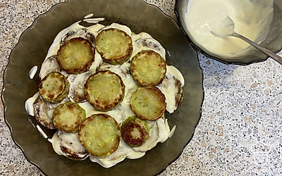 Обжаренные кабачки выложите слоями. Слои хорошо промажьте майонезом с чесноком.