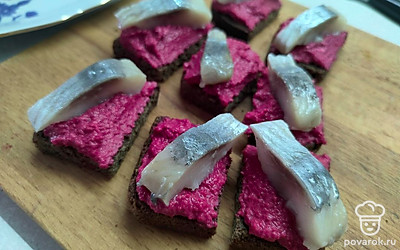 Сверху выложите кусочки сельди. 