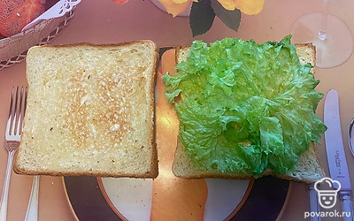 На одну из половинок положите вымытый и просушенный лист салата.