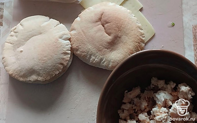 Сыр нарежьте тонкими ломтиками. Питу разрежьте вдоль и начините ее сыром и фаршем. Лепешки доведите до готовности в микроволновке или духовке, чтобы сыр расплавился.