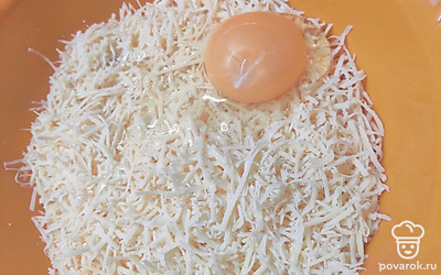 Добавьте к тертому сыру одно яйцо.