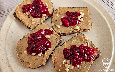 Добавьте малиновое варенье и кедровые орехи. Равномерно распределите начинку по ломтикам. По желанию, можете соединить два ломтика в сэндвич.