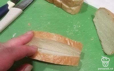 Батон нарежьте кусочками с кармашком. В этот кармашек выложите начинку. Отрезайте кусок батона шириной 1,5 сантиметра и потом этот кусочек еще раз разрежьте пополам, только не до конца, чтобы открывался как книжка.