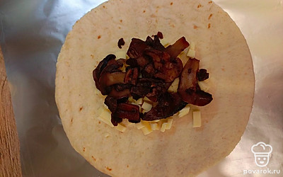 На лепешку выложите сыр, грибы.