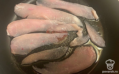 Очень тонко нарежьте куриное филе. Разложите на сковороде с маслом.