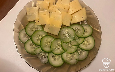 Очень тонко нарежьте огурец и сыр.