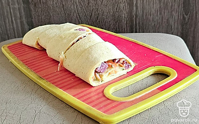 Нарежьте колбасу. Сверните лаваш в рулет.