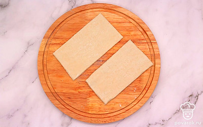 Разморозьте слоеное тесто согласно инструкции на упаковке. Затем тесто немного раскатайте и нарежьте на прямоугольники.