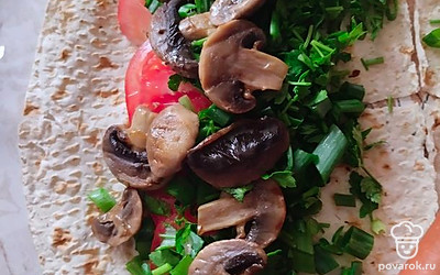 Добавьте помидоры, зелень, грибы и сосиски. Аккуратно и плотно заверните тортилью. Обжарьте в электрогриле или на сковороде до хрустящей корочки.