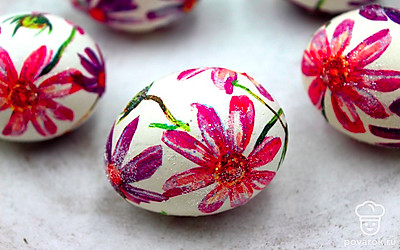 Поверх рисунков нанесите блестки, их тоже можно закрепить яичным белком. При желании с помощью красителей можно окрасить какие-то отдельные фрагменты рисунков, сделав их более яркими. После нанесения блесток и красок дайте декору просохнуть.