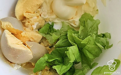 Сделайте начинку. Желток разломайте, добавьте нарезанные листья салата и майонез. Все перемешайте. 