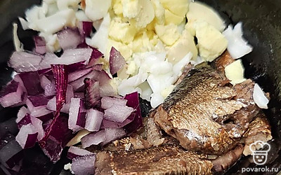 Мелко нарежьте лук, выложите желток и шпроты.