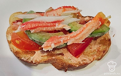 Клешни камчатского краба отварите в воде 3-5 минут, достаньте мясо и выложите на брускетту. 
