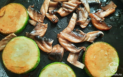 Грибы нарежьте небольшими кусочками, кабачок — кружками.
Отправьте шампиньоны и кабачок жариться на растительном масле. 
Посолите, поперчите и добавьте соевый соус.