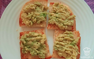 Выложите мякоть авокадо на хлеб, распределите вилкой. Авокадо должно быть зрелым и мягким.