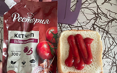 Один ломтик хлеба обильно смажьте вкусным кетчупом.