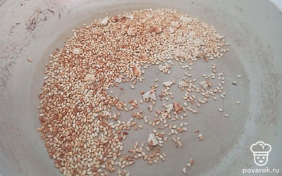 Арахис мелко подробите ножом. Обжарьте вместе с кунжутом до золотистого цвета примерно 3-5 минут. 