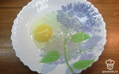 В тарелку разбейте куриное яйцо. 