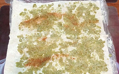 Консервированный горошек разомните до однородной массы. Распределите по лавашу и посыпьте красным молотым перцем. 