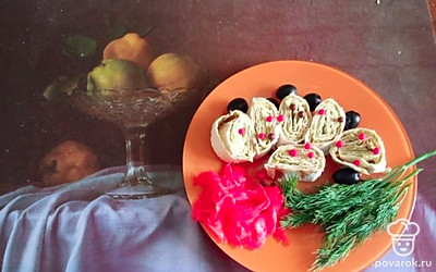 Достаньте лаваш из пищевой пленки. Нарежьте аккуратными ломтиками. Разложите на тарелку. Украсьте маслинами и маринованным имбирем. Также подойдет любая пряная зелень. 