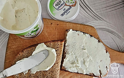 Разрежьте ломтик на две равные части. Смажьте творожным сыром. 