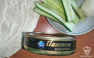 Тортилью смажьте майонезом, огурцы нарежьте пластинками.