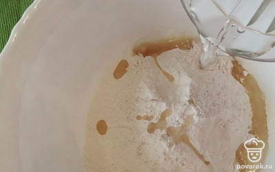 Добавьте крутой кипяток и быстро замешайте тесто. 