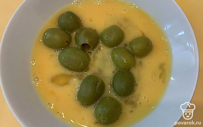 Яйцо перемешайте, обваляйте в нем оливки.