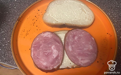Колбасу нарежьте тонкими пластинками.