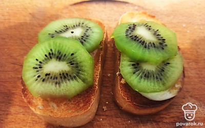 Выложите дольки киви на тосты и подайте к столу.