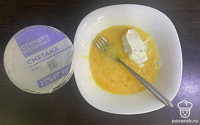 В тарелку вбейте яйца и добавьте сметану, перемешайте.