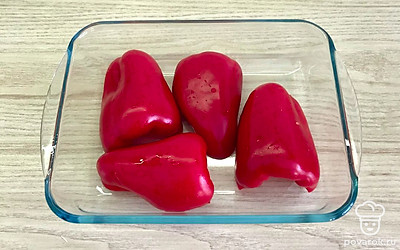 Перец разрежьте на половинки. Выньте семенную коробку, уложите срезом вниз в форму для запекания. Запекайте при температуре 200 градусов 20 минут.