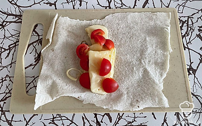 Выложите на лаваш сыр, помидоры черри разрежьте. Добавьте к сыру.