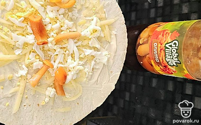 Измельчите на терке вареное яйцо. Выложите маринованные грибы.