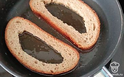 В двух кусочках хлеба вырежьте мякиш и обжарьте на сковородке.