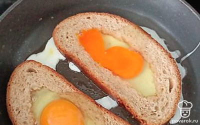 Разбейте яйца в кусочке хлеба.