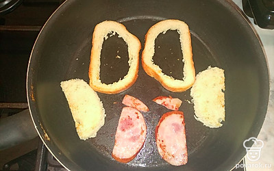 Обжарьте до зарумянывания хлеб и колбасу на сливочном масле.