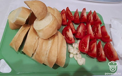 Нарежьте багет, помидоры и чеснок. 