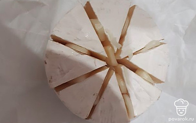 Сыр нарежьте на сегменты, между ними выложите нарезанный чеснок. 