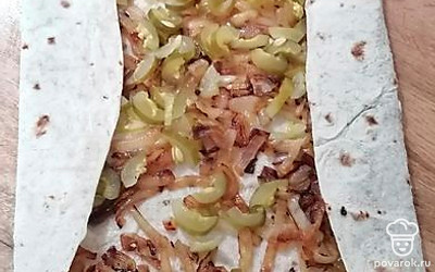 Заверните лаваш по бокам. Затем плотно сверните в трубочку.