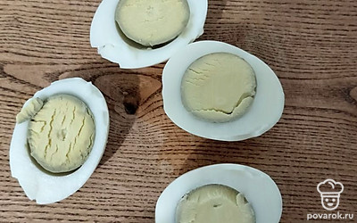 Отварите яйца в течение 10 минут вкрутую. Разрежьте их пополам. Желтки отделите, переложите в глубокую миску, помните их вилкой.